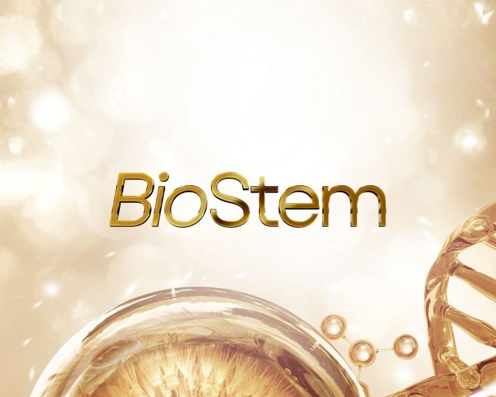 The gold BioStem wordmark set against a warm, shimmering backdrop with a DNA helix and molecular motifs.